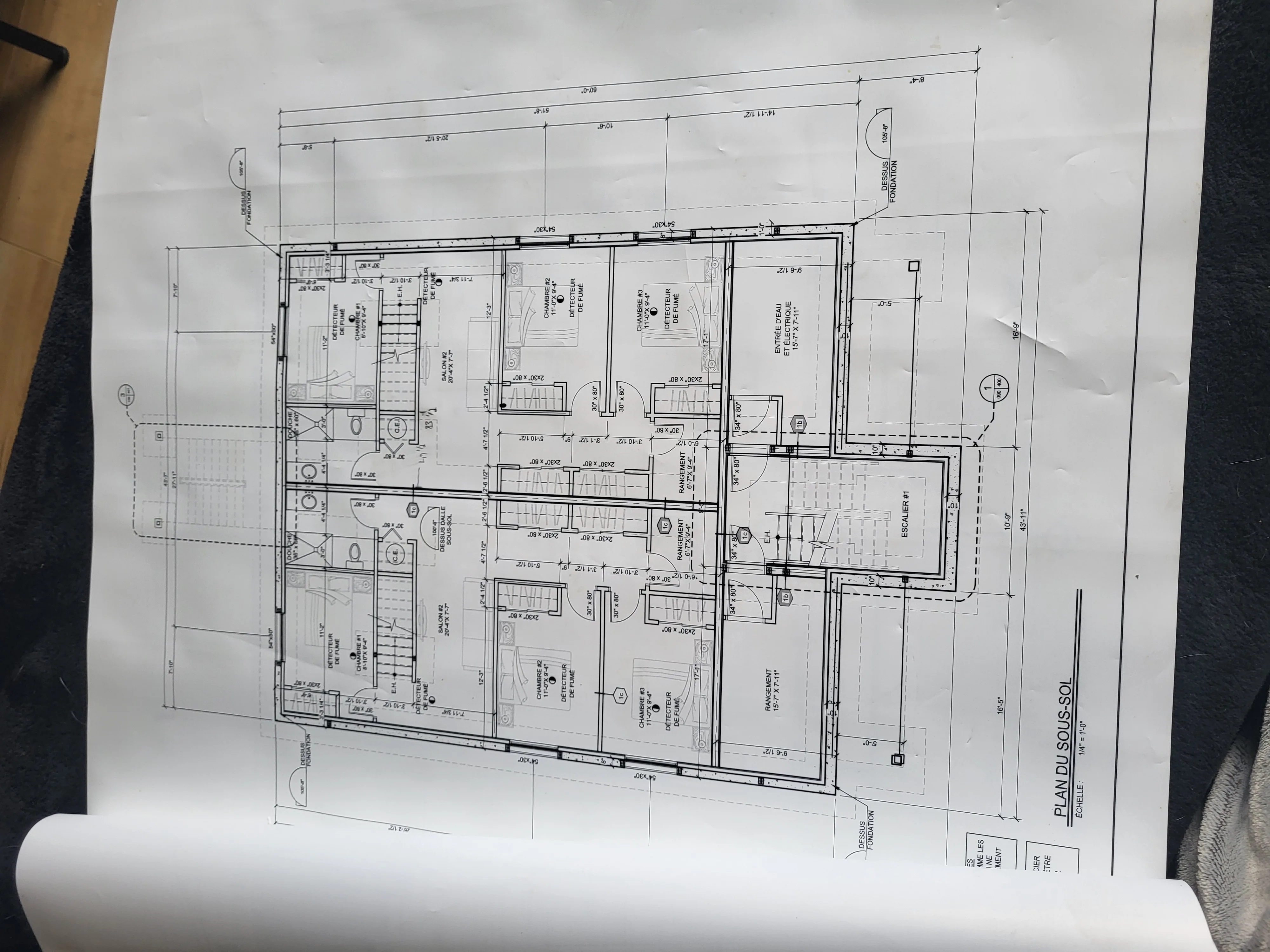 Plan d'architecture d'une résidence déroulé sur une table de chantier